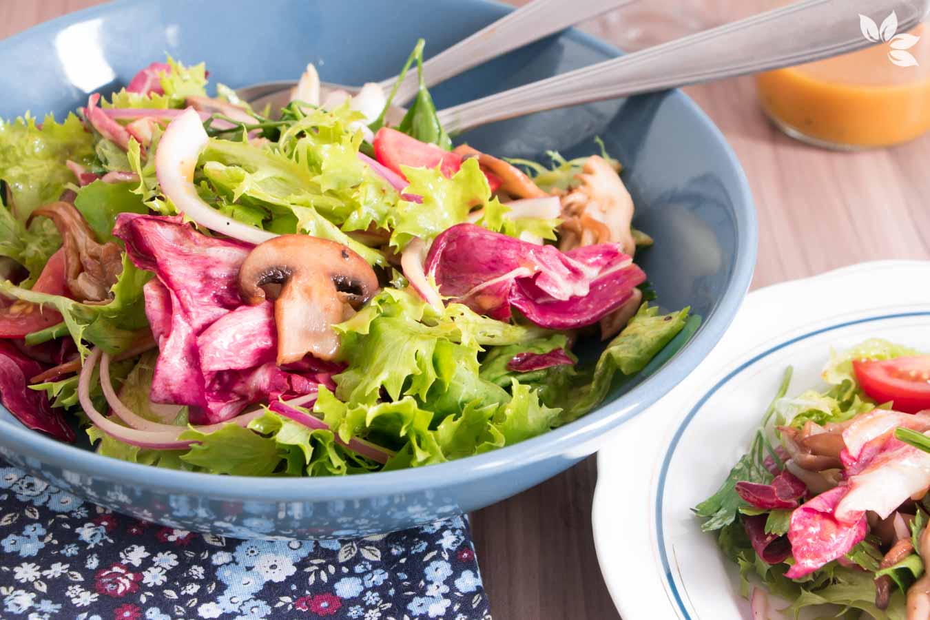 Salada de folhas verdes com cogumelos caramelizados, servida em um prato fundo azul.